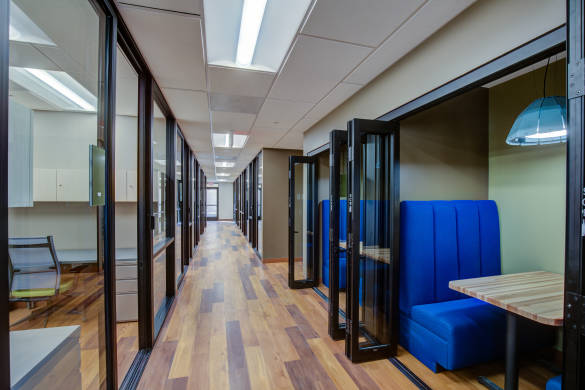 Coworking space with private office on left and work booths on right