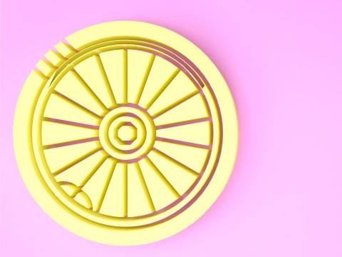 Yellow wheel in front of a pink background