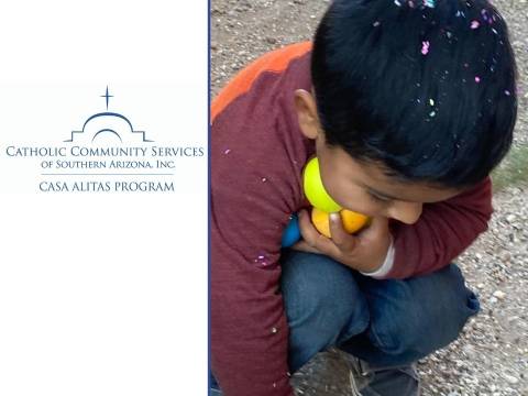 Photo of young child picking up colorful Easter eggs