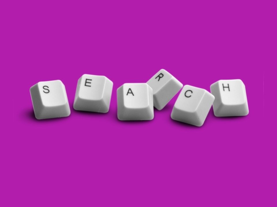 Computer keys spelling out, "search," in front of a purple background.