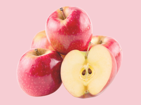 Five pink lady apples in front of a pink background
