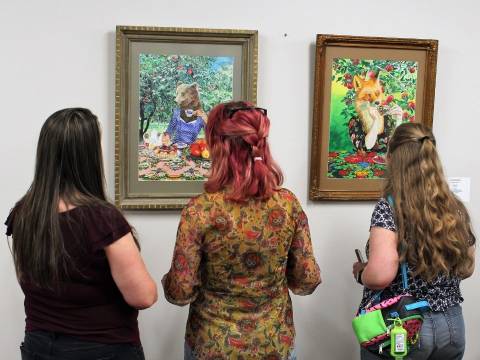 People admiring local artwork displayed at CF campus.