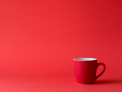 red mug in front of a red background