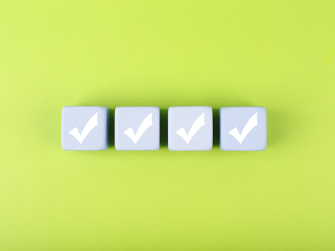 Four checkmark boxes lined up in front of a green background