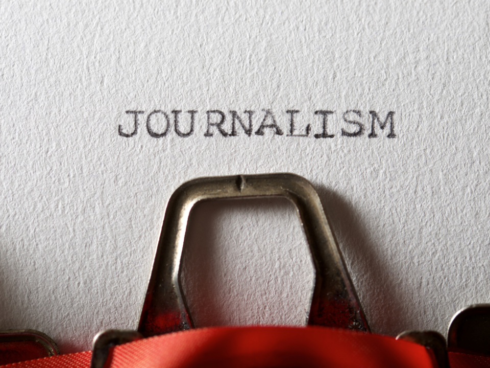 A white wall that says journalism