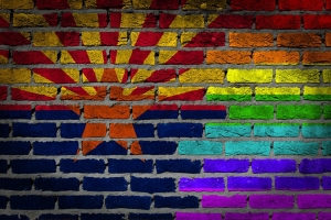 Arizona flag and LGBTQ+ rainbow flag painted on a brick wall
