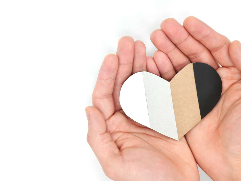 Hand holding a multicolored paper heart