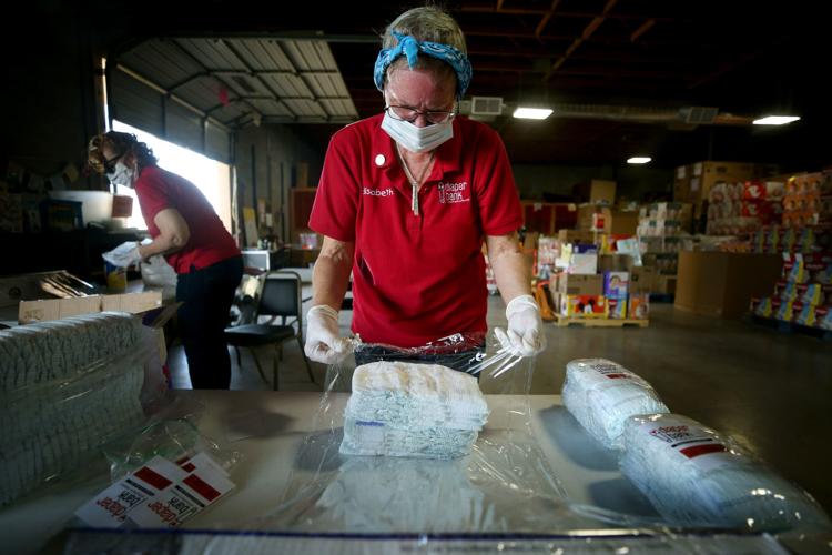 Woman in protective mask wraps diapers in plastic