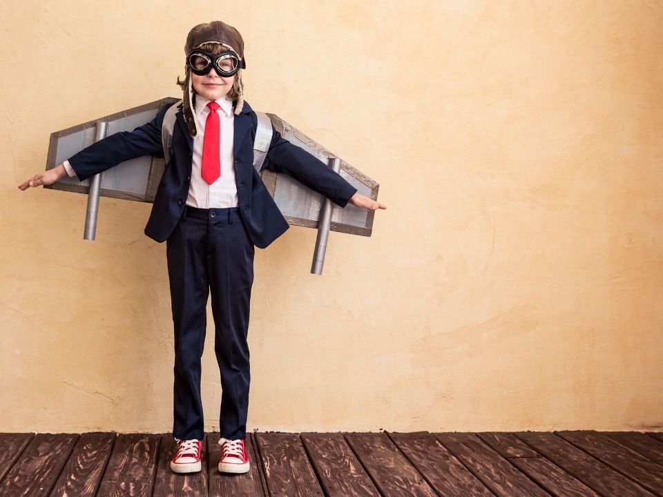 Little boy wearing suit with mask and wings